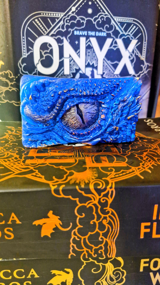 Blue dragon-shaped object on a decorative box with 'ONYX Storm' branding. The Empyrean Series Books. Xaden Riorson dragon