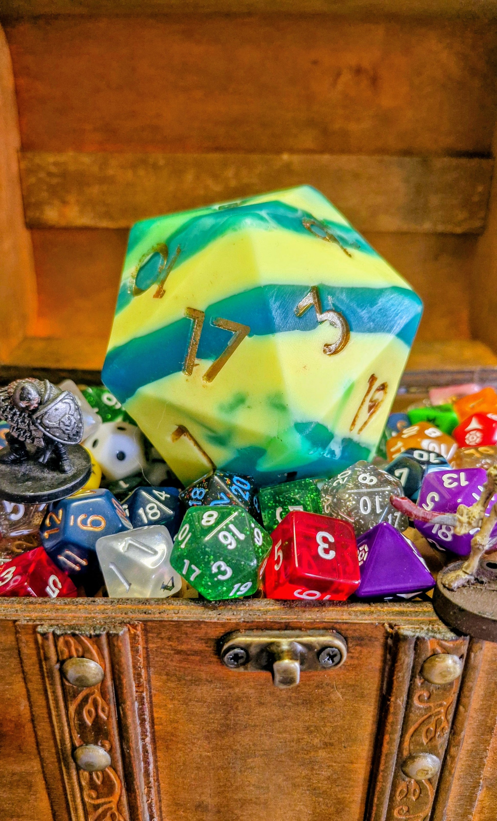 Handmade D20 soap dice in Outrider Games yellow and blue colours, scented with sea salt and sage, displayed on wood with a natural fantasy theme – exclusive collaboration between The Druid’s Grove and Outrider Games Lichfield